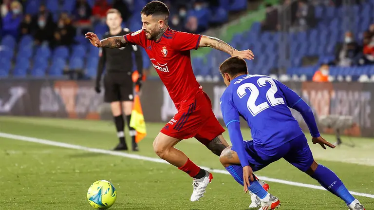 El centrocampista de Osasuna, Rubén García (i), con el balón ante el defensa uruguayo del Getafe, Damián Suárez, durante el encuentro correspondiente a la jornada decimoctava de primera división que disputan hoy domingo en el coliseum Alfonso Pérez de la localidad madrileña. EFE / Mariscal.