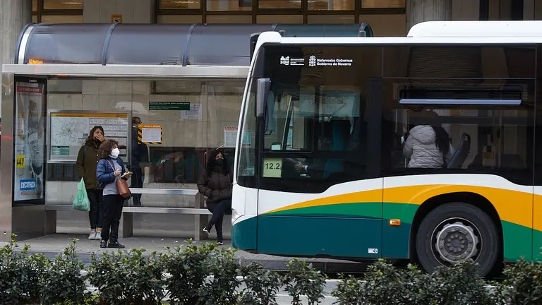 Varias personas esperan a la villavesa en una parada de Conde Oliveto en Pamplona tras la recuperación de la obligatoriedad del uso de las mascarillas en exteriores. IÑIGO ALZUGARAY