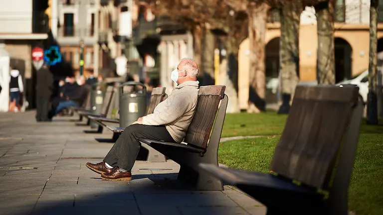 Un hombre toma el sol en un banco de la Plaza del Castillo de Pamplona durante una mañana de invierno. PABLO LASOSA