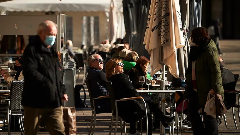Varias personas sentadas en una terraza de la Plaza del Castillo de Pamplona durante una mañana de invierno. PABLO LASAOSA
