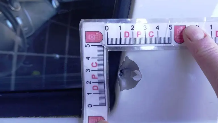 Impacto de bala en el marco de la puerta del coche de la mujer a la que su exmarido junto con su actual pareja han intentado asesinar en la carretera N-121-A. TWITTER POLICÍA FORAL