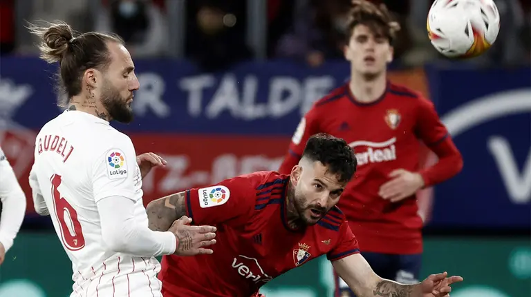 Rubén García ante Gudelj en el partido Osasuna - Sevilla en Pamplona.. EFE/Jesus Diges