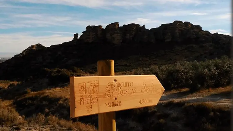Señal del Circuito de Roscas en Fitero, con la formación geológica de fondo. AYUNTAMIENTO DE FITERO