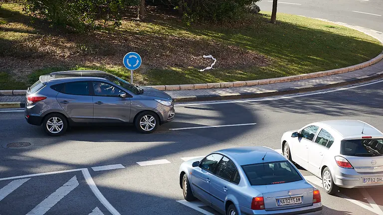 Varios coches pasan por una rotonda en Pamplona. PABLO LASAOSA