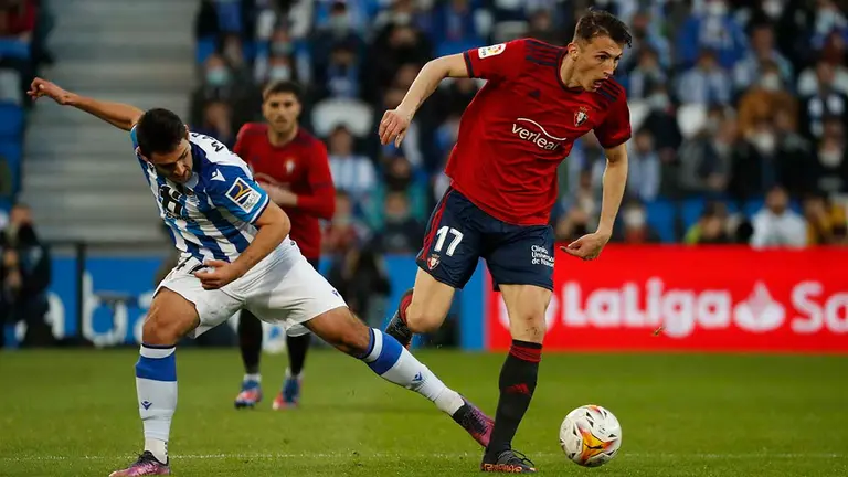 El delantero de la Real Sociedad Ander Martín (i) y el delantero croata del Osasuna Ante Budimir luchan por el balón durante el partido de Liga que disputan este domingo en el estadio Reale Arena de San Sebastian. EFE/ Javier Etxezarreta
