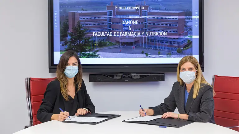 Isabel Pérez, del área de Nutrición y Sostenibilidad de Danone Iberia, y María Javier Ramírez, decana de la Facultad de Farmacia y Nutrición, durante la firma del convenio. UNIVERSIDAD DE NAVARRA