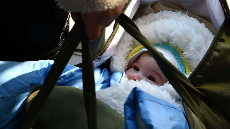 Una mujer lleva un bebé mientras espera el tren de evacuación en la estación de tren de Kramatorsk, Ucrania. Andriy Andriyenko / Zuma Press / ContactoPhoto