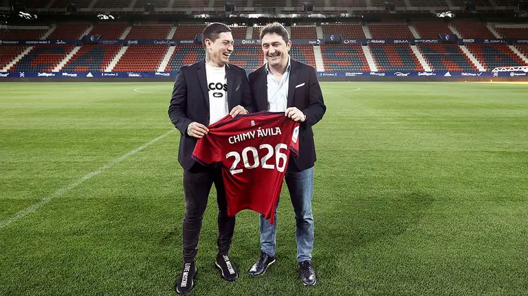 El delantero argentino de Osasuna Chimy Ávila (i) y el director deportivo, Braulio Vázquez (d), posan en la tarde de este miércoles en el terreno de juego del estadio de El Sadar tras su renovación con el equipo rojillo hasta junio del 2026 con una clausula de rescisión de 30 millones de euros.  EFE/ Jesús Diges