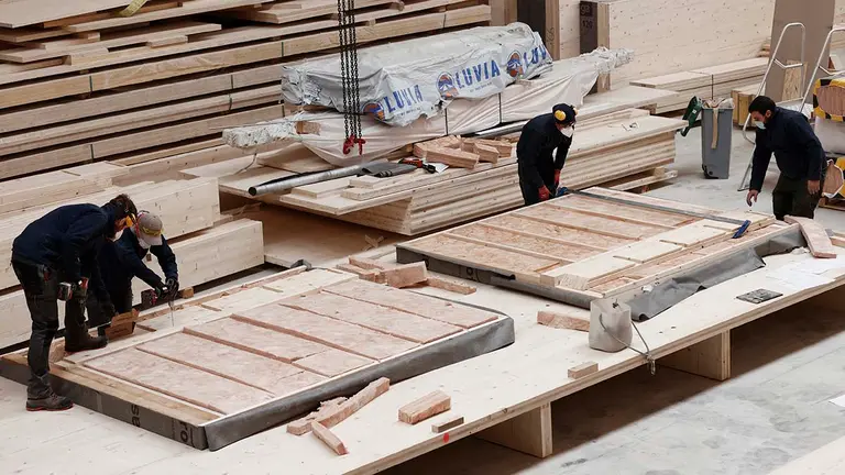 Varios trabajadores de la empresa Madergia terminan de elaborar una pared de madera para su uso en un futuro edificio. Madergia utiliza fundamentalmente madera de conífera, “cuya relación entre prestaciones y precio es muy alta y además es de un crecimiento más rápido que otras especies que en general tienen otros usos que no son el de la construcción”. La apuesta de Navarra por este novedoso sector se materializará próximamente con la construcción en el barrio de Azpilagaña de Pamplona de un edificio comunitario de nueve alturas para personas de más de 60 años. Será la torre construida en madera más alta de España y supondrá en sí misma la reivindicación de un material que quizá llevaba demasiado tiempo olvidado.  EFE/ Jesús Diges