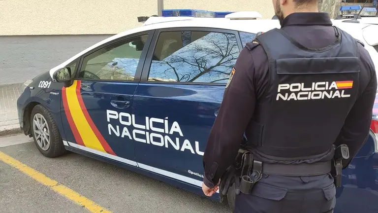 Un agente de la Policía Nacional junto al coche patrulla.
POLICÍA NACIONAL