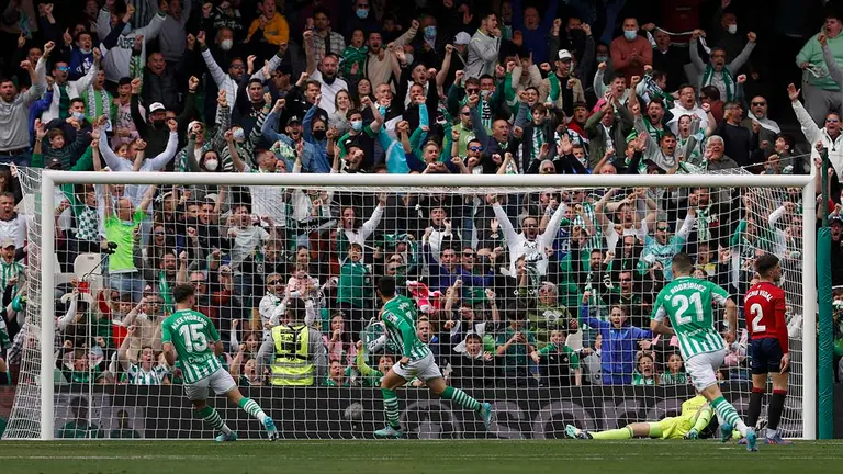 El delantero del Betis, Juan Miguel Jiménez "Juanmi" (c), tras conseguir el segundo del equipo bético durante el encuentro correspondiente a la jornada 30 de primera división que disputan hoy domingo frente a Osasuna en el estadio Benito Villamarín de Sevilla. EFE/Julio Muñoz.