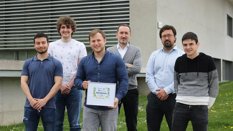 Junto a las oficinas de Tracasa Instrumental, de izquierda a derecha, Christian Ayala, Christian Gutiérrez, Javier Lasheras, Carlos Aranda, Pablo Vega y Rubén Sesma, con el galardón que acredita el primer puesto en la competición internacional de inteligencia artificial. CEDIDA