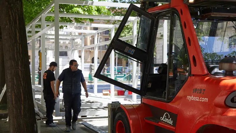Inicio de los trabajos de montaje de la tómbola de Cáritas en el Paseo de Sarasate de Pamplona. IÑIGO ALZUGARAY