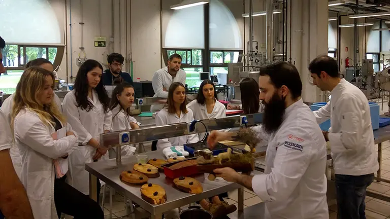 Sergio Lerga y Rodrigo Castillejo explican las distintas elaboraciones del pincho a los y las estudiantes. UPNA