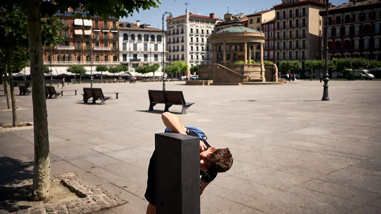 Un joven bebe agua de una fuente durante la ola de calor en junio de 2022. PABLO LASAOSA
