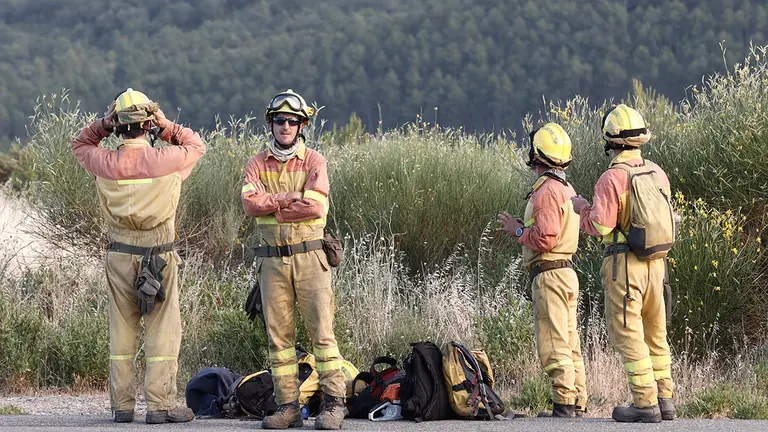 Un retén de bomberos espera a ser trasladado hoy miércoles para trabajar en la extinción del incendio cercano al Monasterio de Leyre, Navarra. Las elevadas temperaturas, la sequedad del suelo y el viento están complicando las tareas de extinción de los tres incendios que se mantienen desde ayer activos en Navarra. Esta tarde han tenido que ser desalojadas de forma preventiva las personas que se encontraban en el monasterio de Leyre, alrededor de 30, ya que el fuego que afecta a la ladera del monte Arangoiti sigue descontrolado, aunque el Gobierno de Navarra ha indicado que no parece existir riesgo de que el monasterio se vea alcanzado por las llamas. EFE/Jesús Diges