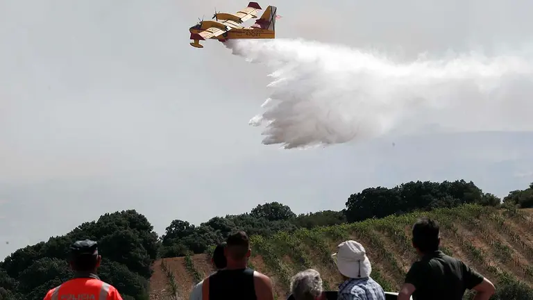 Vista de los trabajos para extinguir el fuego en la localidad de San Martín de Unx, que permanece a primera hora de este domingo desalojada por precaución tras los incendios vividos ayer y esta noche en Navarra. Según informa en sus redes sociales SOS Navarra, hay otras localidades como Azoz, Muskiz y Viguria donde los vecinos han salido por iniciativa propia, pese a que las autoridades no han dado orden de desalojo.- EFE / Villar López