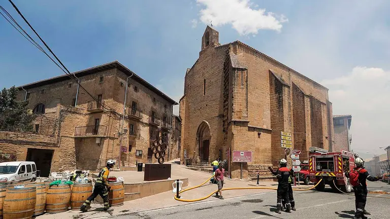 Vista de los trabajos para extinguir el fuego en la localidad de San Martín de Unx, que permanece a primera hora de este domingo desalojada por precaución tras los incendios vividos ayer y esta noche en Navarra.- EFE / Villar López