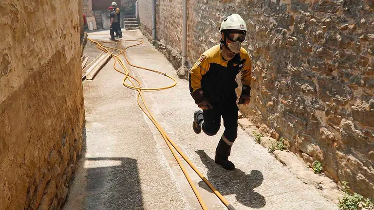 Vista de los trabajos para extinguir el fuego en la localidad de San Martín de Unx, que permanece a primera hora de este domingo desalojada por precaución tras los incendios vividos ayer y esta noche en Navarra.- EFE / Villar López