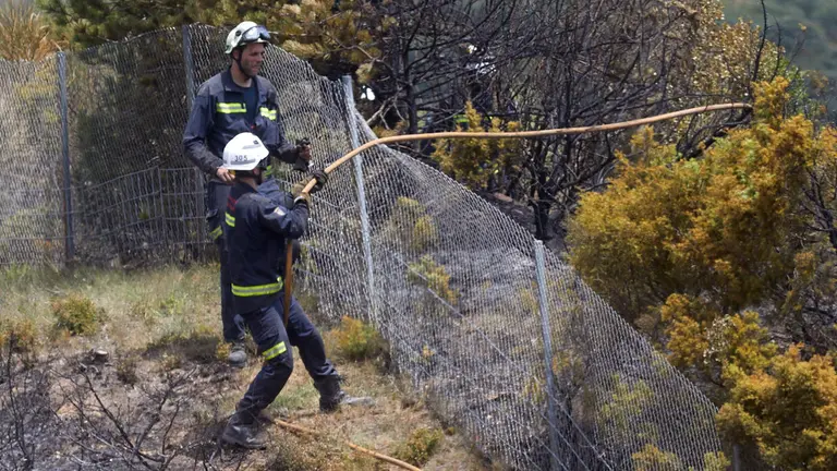 Un retén de bomberos trabajan en la extinción y control del incendio de la sierra del Perdón. IÑIGO ALZUGARAY