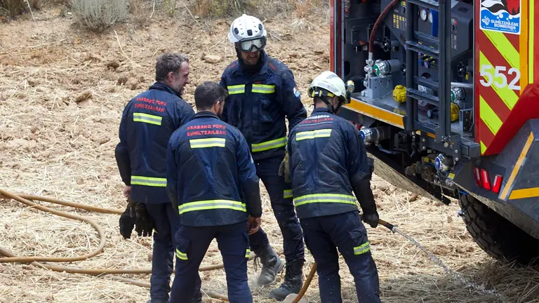 Un retén de bomberos trabajan en la extinción y control del incendio de la sierra del Perdón. IÑIGO ALZUGARAY