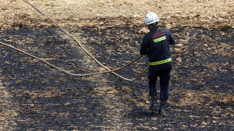Un retén de bomberos trabajan en la extinción y control del incendio de la sierra del Perdón. IÑIGO ALZUGARAY