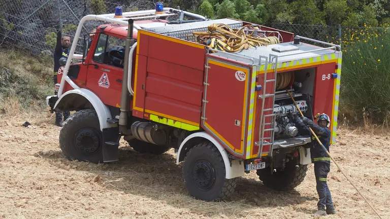 Un retén de bomberos trabajan en la extinción y control del incendio de la sierra del Perdón. IÑIGO ALZUGARAY