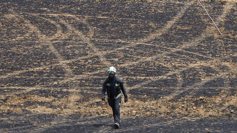 Un retén de bomberos trabajan en la extinción y control del incendio de la sierra del Perdón. IÑIGO ALZUGARAY