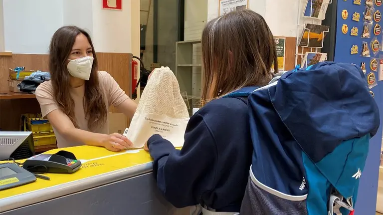 Una trabajadora de Correos ofrece una bolsa a una peregrina. CEDIDA