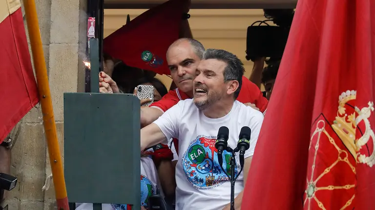 César López ayuda a Juan Carlos Unzué para encender la mecha del cohete de San Fermín.  EFE/Villar Lopez