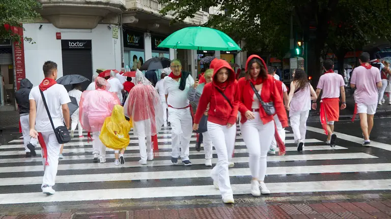 Ambiente por las calles de Pamplona en los momentos posteriores al Chupinazo con el que se ha dado inicio a los Sanfermines 2022, este año con la lluvia como portagonista. IÑIGO ALZUGARAY