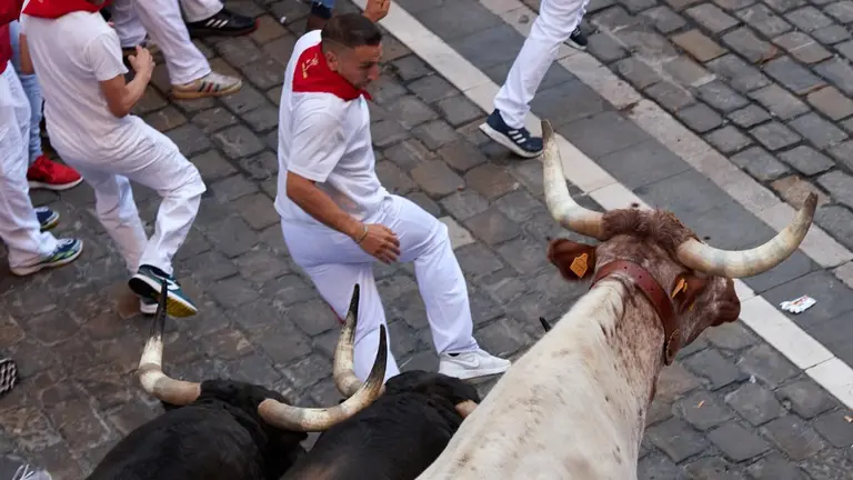 Los toros de la ganadería gaditana de Fuente Ymbro al final del tramo de la cuesta de Santo Domingo durante el segundo encierro de los Sanfermines 2022, una carrera que se ha alargado hasta los 3:10 minutos por un toro rezagado. EFE/J.P. Urdiroz