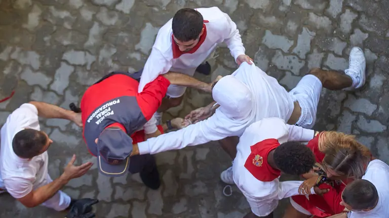 Momentos de tensión entre corredores y la Policía Foral al intentar saltarse el cordón policial para entrar a la plaza tras el final del tercer encierro de San Fermín 2022. IÑIGO ALZUGARAY