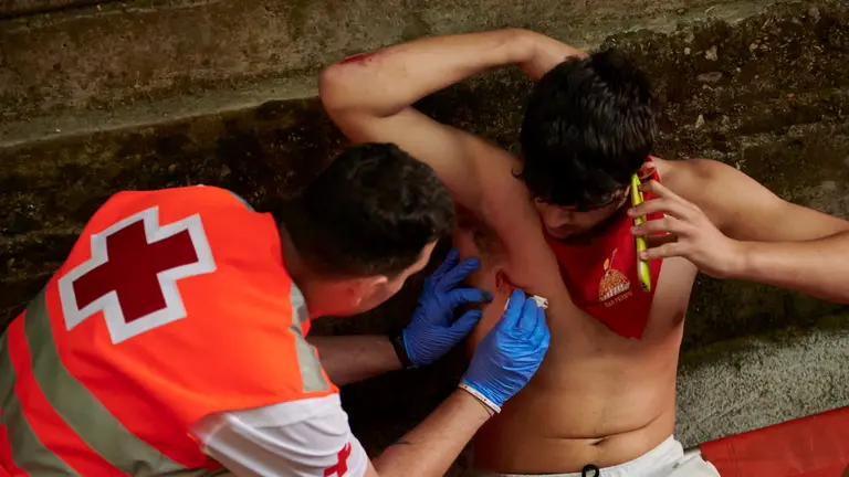 Heridos en el quinto encierro de San Fermín con toros de Cebada Gago en Telefónica bajando al callejón. IRANZU LARRASOAÑA