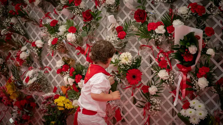 Cientos de niños participan en la tradicional ofrenda floral a San Fermín, que se celebra cada año con motivo del Día infantil de las fiestas. MAITE H. MATEO
