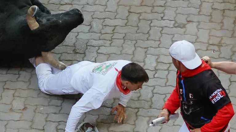 Los toros de la ganadería de Jandilla a su paso por el callejón de entrada a la plaza de toros durante el sexto encierro de los Sanfermines. EFE Villar López 9