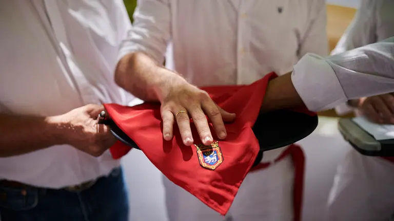 Una persona escoje una de las bolas del sombrero del mayoral donde previamente se han intrudido junto al papel de fumar con los lotes durante el apartado de Jandilla el 12 de julio en San Fermín 2022. PABLO LASAOSA