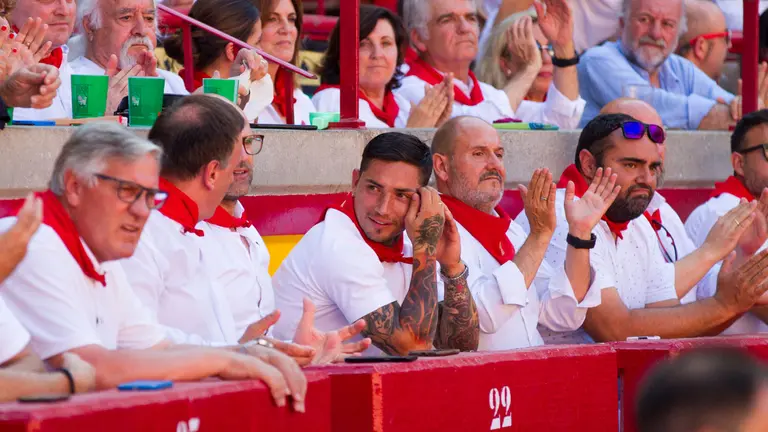 El jugador de Osasuna el Chimy Ávila disfruta de la séptima corrida de toros desde el burladero en la feria del toro de San Fermín 2022. ALEJANDRO VELASCO