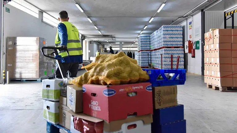 Un voluntario del Banco de Alimentos maneja una carretilla cargada con las donaciones. LA CAIXA