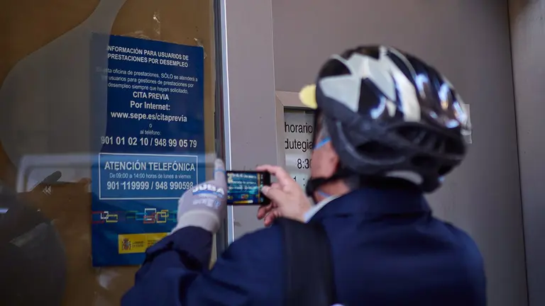 Un hombre saca una foto a un anuncio en una oficinas de empleo en Pamplona. EUROPA PRESS