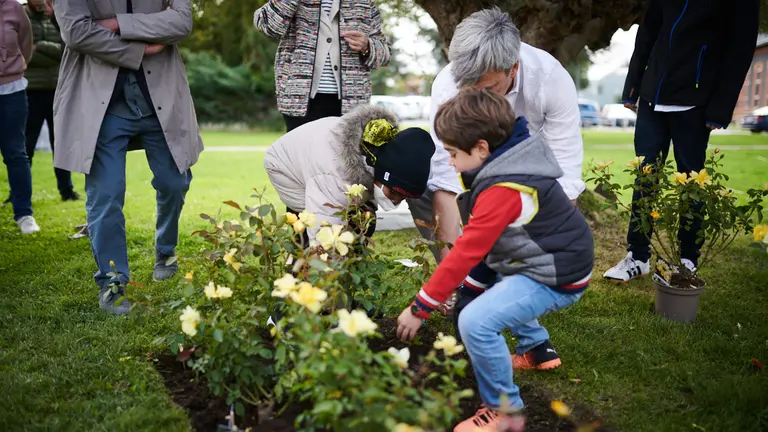 Acto organizado por la Unidad de Innovación Social en colaboración con el Servicio de Jardinería del Hospital Universitario de Navarra en el que niños plantan un rosal junto al busto de Santiago Ramón y Cajal. PABLO LASAOSA