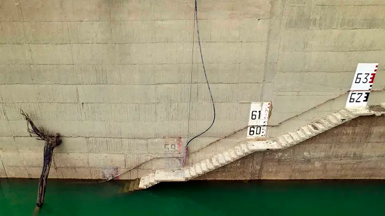 Imagen tomada desde un dron de la pared de la presa de Yesa. El embalse de Yesa se encuentra a un nivel de llenado de 52,9 hectómetros cúbicos, el quinto dato más bajo desde que se tienen registros y el más bajo de los últimos 21 años. En comparación con los datos que registraba el embalse hace un año, que eran de 71,3 hectómetros cúbicos, Yesa ha bajado en 18 hm3, y en 39,2 con respecto a la media de los últimos cinco años. El agua de boca está garantizada y con la campaña de riego ya finalizada, la Confederación Hidrográfica del Ebro (CHE) espera que el otoño sea lluvioso para poder recuperar los niveles habituales y que el verano que viene no se sufra por escasez. Durante esta campaña de riego se han tenido que hacer ajustes debido a la escasez del pantano y ha terminado 15 días antes de lo previsto.EFE/ Jesús Diges