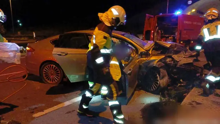 Los bomberos trabajan en el desatrapamiento de un herido en el interior de un coche esta madrugada en los túneles de Ezcaba. BOMBEROS DE NAVARRA