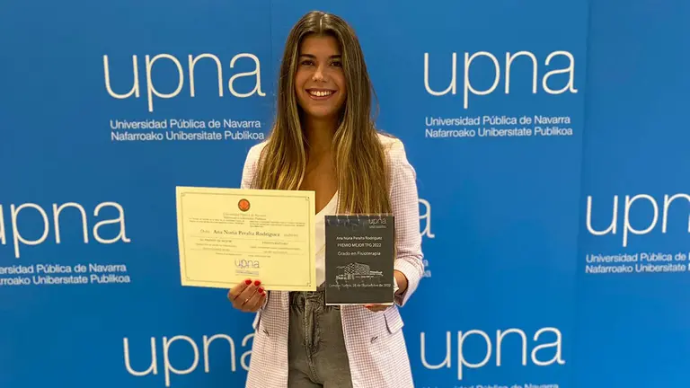 Ana Nuria Peralta, ganadora del premio TFG en Fisioterapia, posa con su diploma y galardón. UPNA
