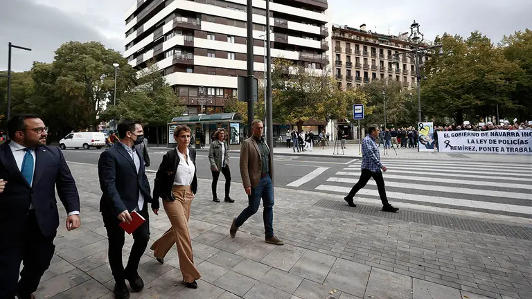 a presidenta del Gobierno de Navarra, Maria Chivite (3i), y el vicepresidente del Gobierno foral Javier Remírez (i), llegan al Parlamento de Navarra donde agentes de la Policía Foral han vuelto a concentrarse para denunciar que el Gobierno "incumple" los compromisos respecto a la Ley de Policías y lo han hecho poniendo el foco en la presidenta María Chivite, a quien ha exigido que "reglamente o dimita".  EFE/ Jesus Diges