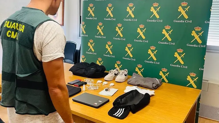 Un agente de la Guardia Civil junto con los objetos robados. 
 GUARDIA CIVIL