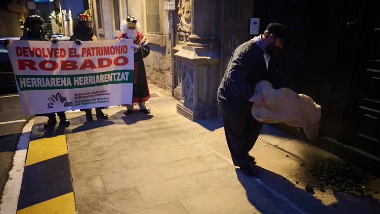 Los Reyes Magos y Olentzero entregan carbón al arzobispo, tras una kalejira convocada por la Plataforma de Defensa del Patrimonio Navarro para rechazar las inmatriculaciones de bienes públicos por parte de la Iglesia. PABLO LASAOSA