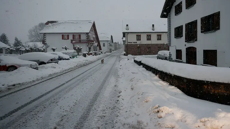 GRAFCAV4163. ESPINAL, 18/01/2023.- Un perro camina sobre la carretera que atraviesa Espinal donde el temporal de nieve que afecta sobre todo al norte de la comunidad se ha reactivado esta tarde produciéndose cortes en algunas de las carreteras. La Agencia Estatal de Meteorología ha dado alerta naranja por nieve este miércoles para toda Navarra salvo la Ribera y de nivel amarillo por riesgo de aludes para Pirineos. Según indica la Aemet, en Pirineos se puede alcanzar un espesor de nieve de 20 centímetros en 24 horas a partir de los 900-1000 metros de altitud, y en la vertiente cantábrica y el centro de la comunidad, 10 centímetros en 24 horas, por encima de los 500 metros en la vertiente cantábrica y de los 700 en el centro de la comunidad, aunque la cota de nieve estará situada en torno a los 300-400 metros. EFE/ Jesús Diges
