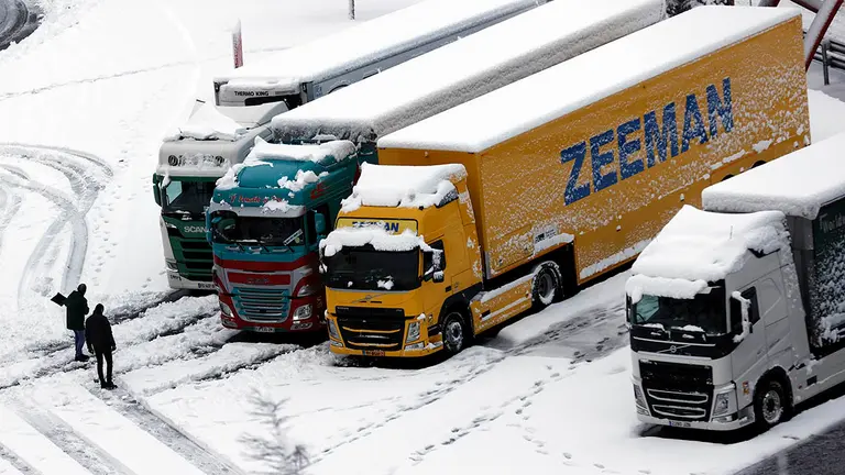 GRAFCAV4136. GORRITI, 18/01/2023.- Dos camioneros limpian de nieve la calzada en el area de servicio de Pagozelay, la autovía ha permanecido cerrada en la zona de guipúzcoa durante unas horas pero ya se circula con normalidad. La Agencia Estatal de Meteorología ha dado alerta naranja por nieve este miércoles para toda Navarra salvo la Ribera y de nivel amarillo por riesgo de aludes para Pirineos.Según indica la Aemet, en Pirineos se puede alcanzar un espesor de nieve de 20 centímetros en 24 horas a partir de los 900-1000 metros de altitud, y en la vertiente cantábrica y el centro de la comunidad, 10 centímetros en 24 horas, por encima de los 500 metros en la vertiente cantábrica y de los 700 en el centro de la comunidad, aunque la cota de nieve estará situada en torno a los 300-400 metros. EFE/ Jesús Diges
