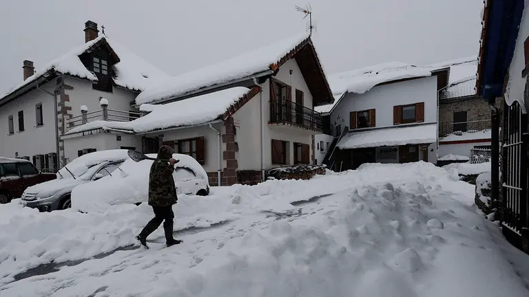 GRAFCAV4160. BURGUETE, 18/01/2023.- Una persona retira la nieve de un vehículo en la localidad de Espinal, el temporal de nieve que afecta sobre todo al norte de la comunidad se ha reactivado esta tarde produciéndose cortes en algunas de las carreteras. La Agencia Estatal de Meteorología ha dado alerta naranja por nieve este miércoles para toda Navarra salvo la Ribera y de nivel amarillo por riesgo de aludes para Pirineos. Según indica la Aemet, en Pirineos se puede alcanzar un espesor de nieve de 20 centímetros en 24 horas a partir de los 900-1000 metros de altitud, y en la vertiente cantábrica y el centro de la comunidad, 10 centímetros en 24 horas, por encima de los 500 metros en la vertiente cantábrica y de los 700 en el centro de la comunidad, aunque la cota de nieve estará situada en torno a los 300-400 metros. EFE/ Jesús Diges
